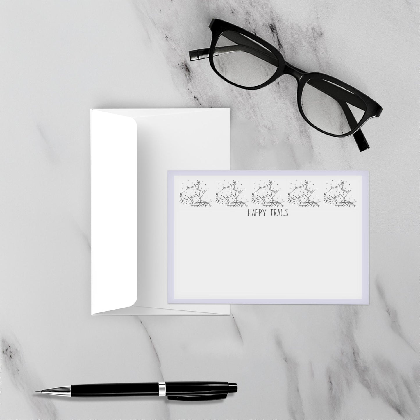 Flat note card Happy Trails with envelope on a marble background with black reading glasses and a black fountain pen