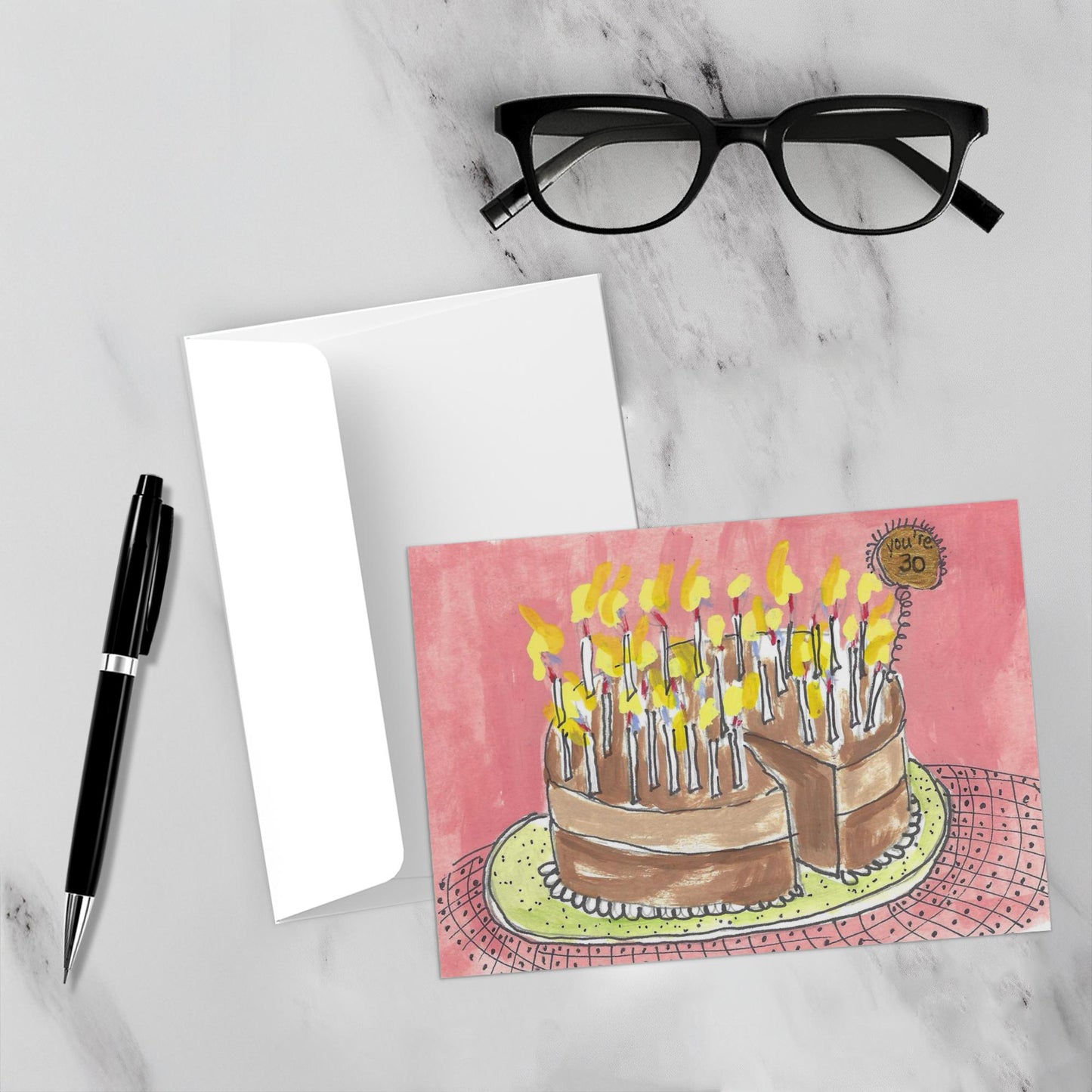Front view of the greeting card You're 30! with a black fountain pen and black rimmed reading glasses on a white marble background.