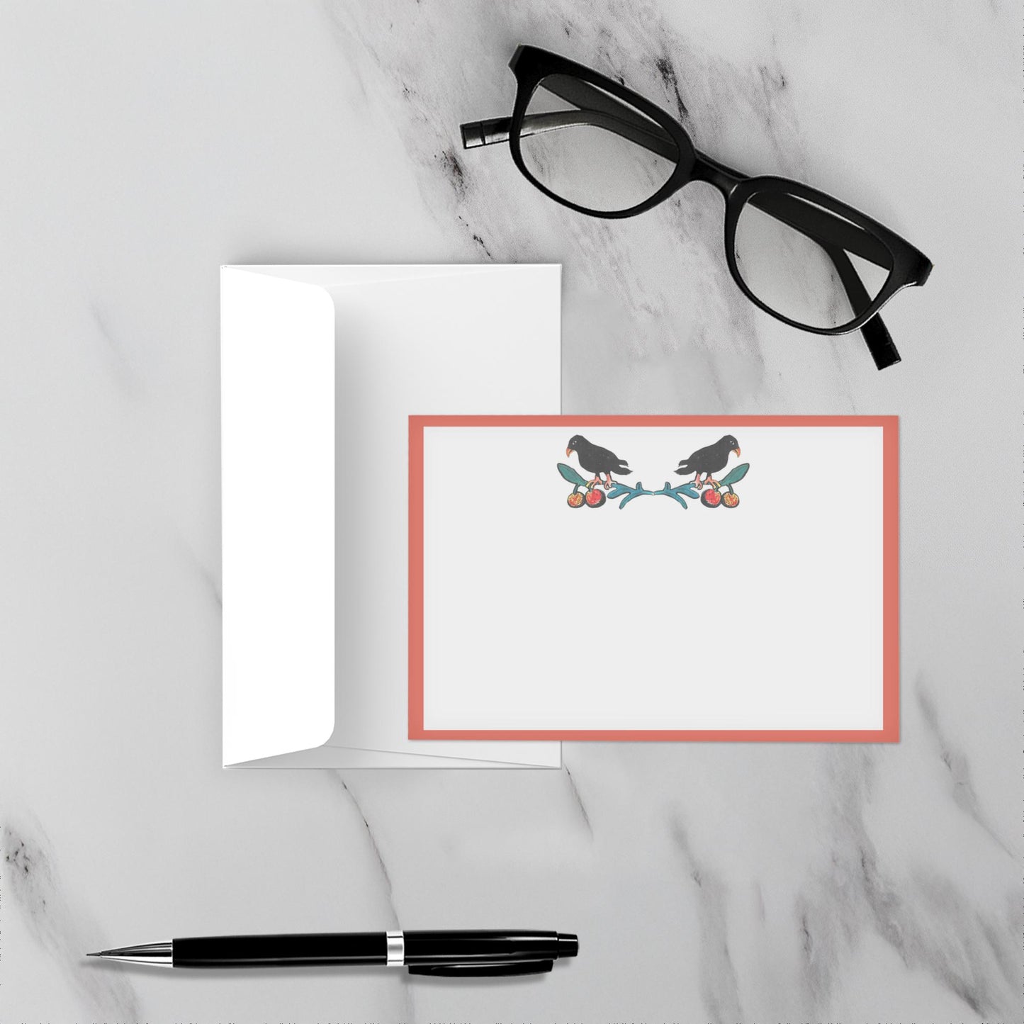 Note card with bird design on a marble surface with glasses and pen.