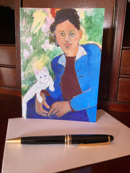 Mockup of the front of the greeting card on a wooden desk with the envelope and a pen.