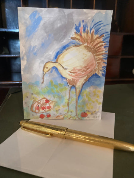 Photograph of the Vermont Turkey greeting card showing the card upright on a desk with a partial view of a white envelope and a gold pen.