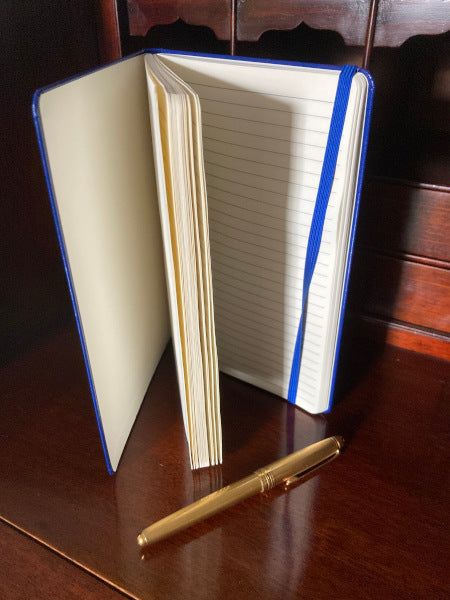 Mockup of the journal Yellow Haired Girl atop a wooden desk with the pages fanned out.