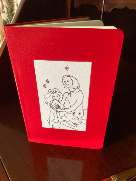 Mockup of On Being Idolized journal book in red with the front cover showing. The black and white image with the floating red hearts really stand out against this color.