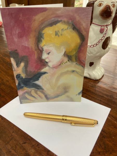 Mock up of the front of the card leaning against a white and brown Staffordshire dog. They are positioned on a wooden table. The envelope and a pen are beneath the card.