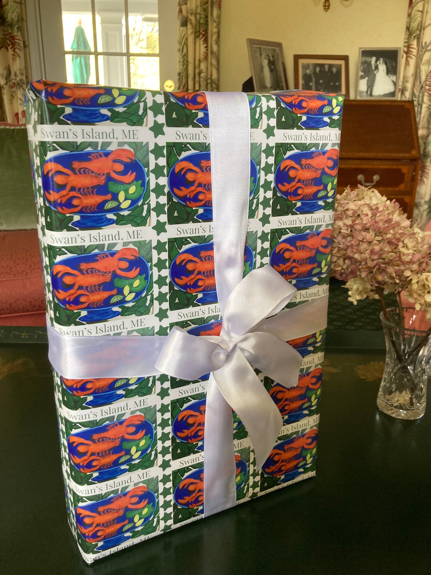 The vivid red, blue, green and white on the Swan's Island Wrapping Paper displays nicely in this mock up of a wrapped present with a white bow.
