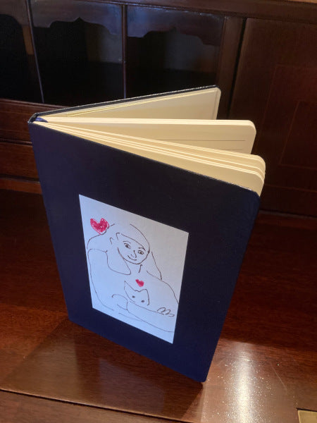Mock up of Armful of love on a navy journal set on a wooden table.