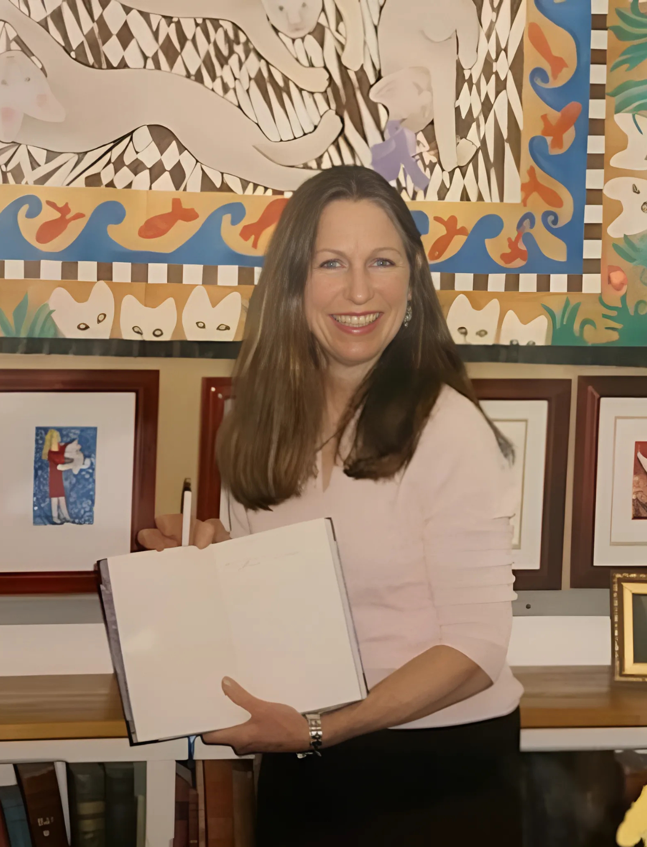 The beautiful and talented Janet Lee Chauncey at her art show in South Londonderry Vermont. She is stands with her guest book surrounded by her colorful art.