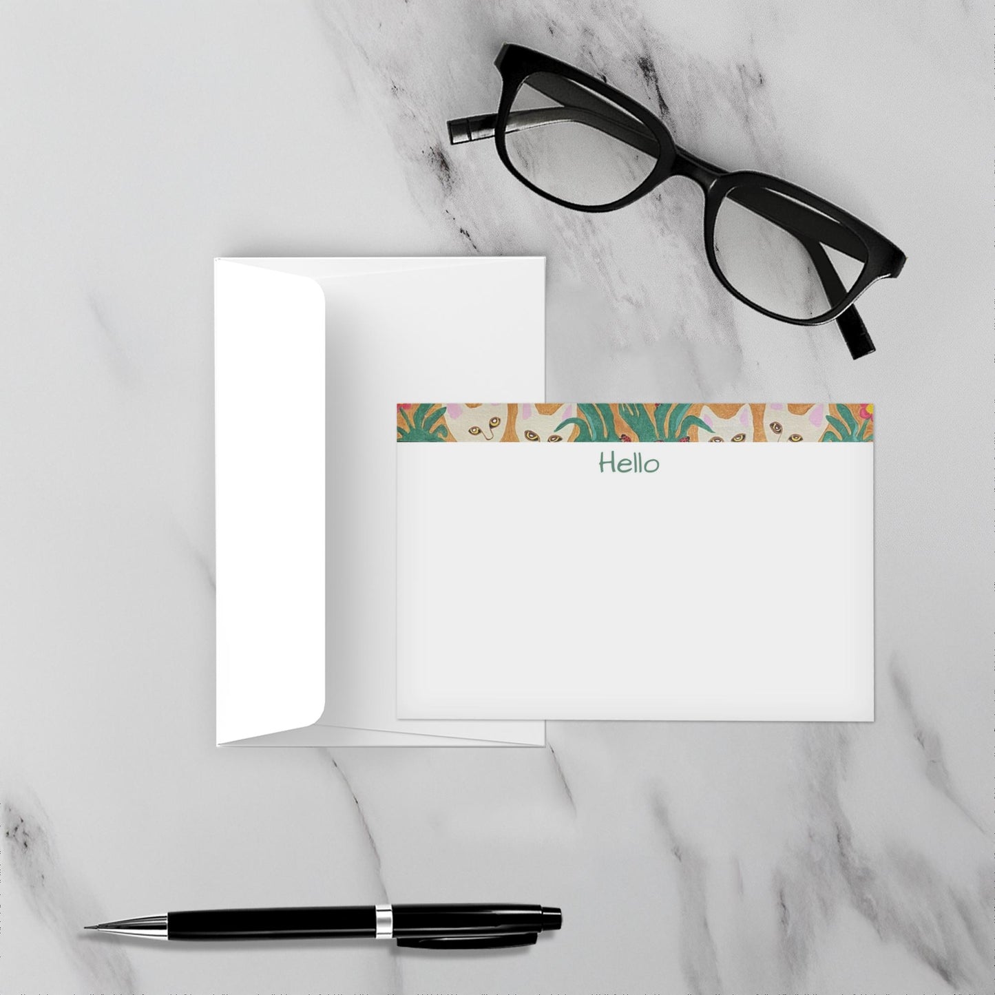 Note card with floral design and Hello text on a marble surface with glasses and pen.