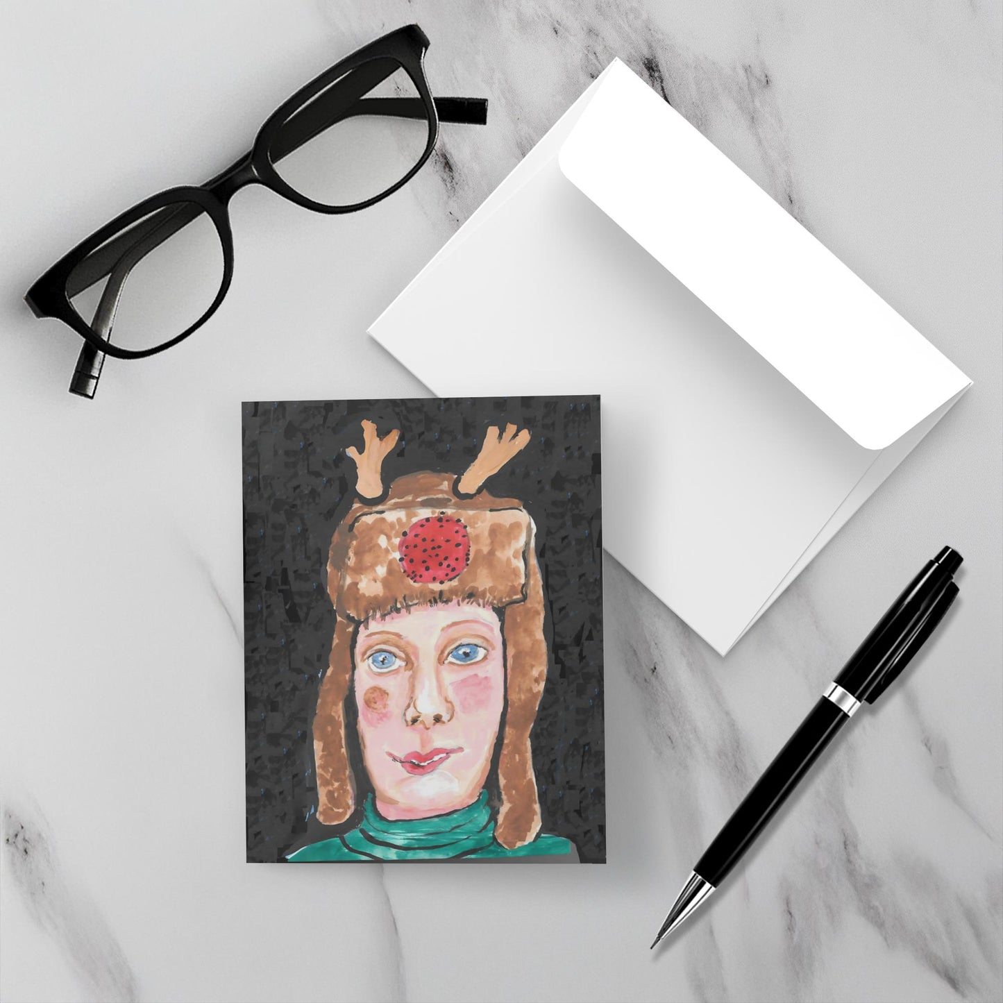 Mockup display showcasing the front of the greeting card Girl From Maine lying on a gray marble surface along side a white envelope, a pair of black reading glasses and a black pen.