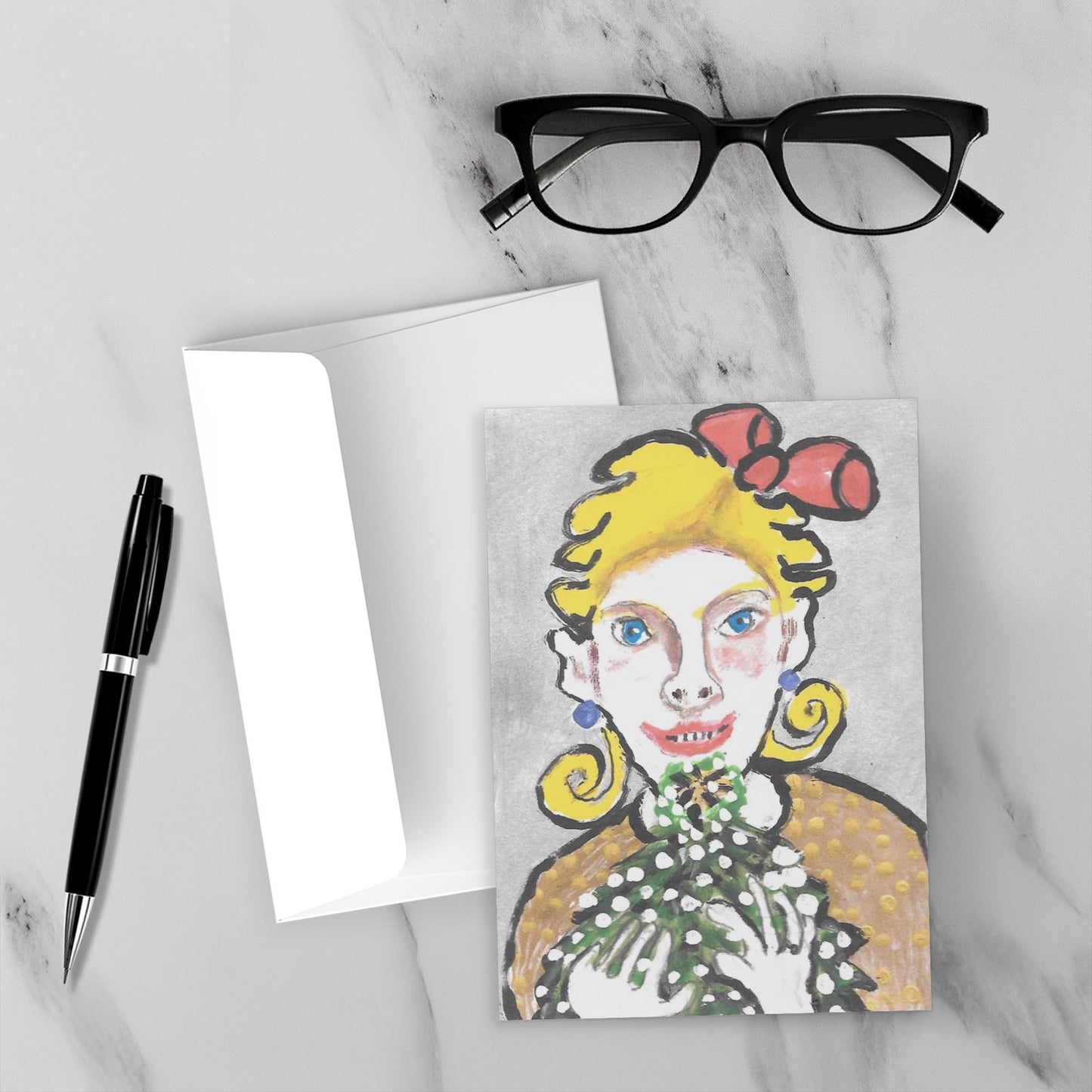 Mockup of A Beautiful Feeling Christmas card on a white marble background with its envelope and a black pen and reading glasses.
