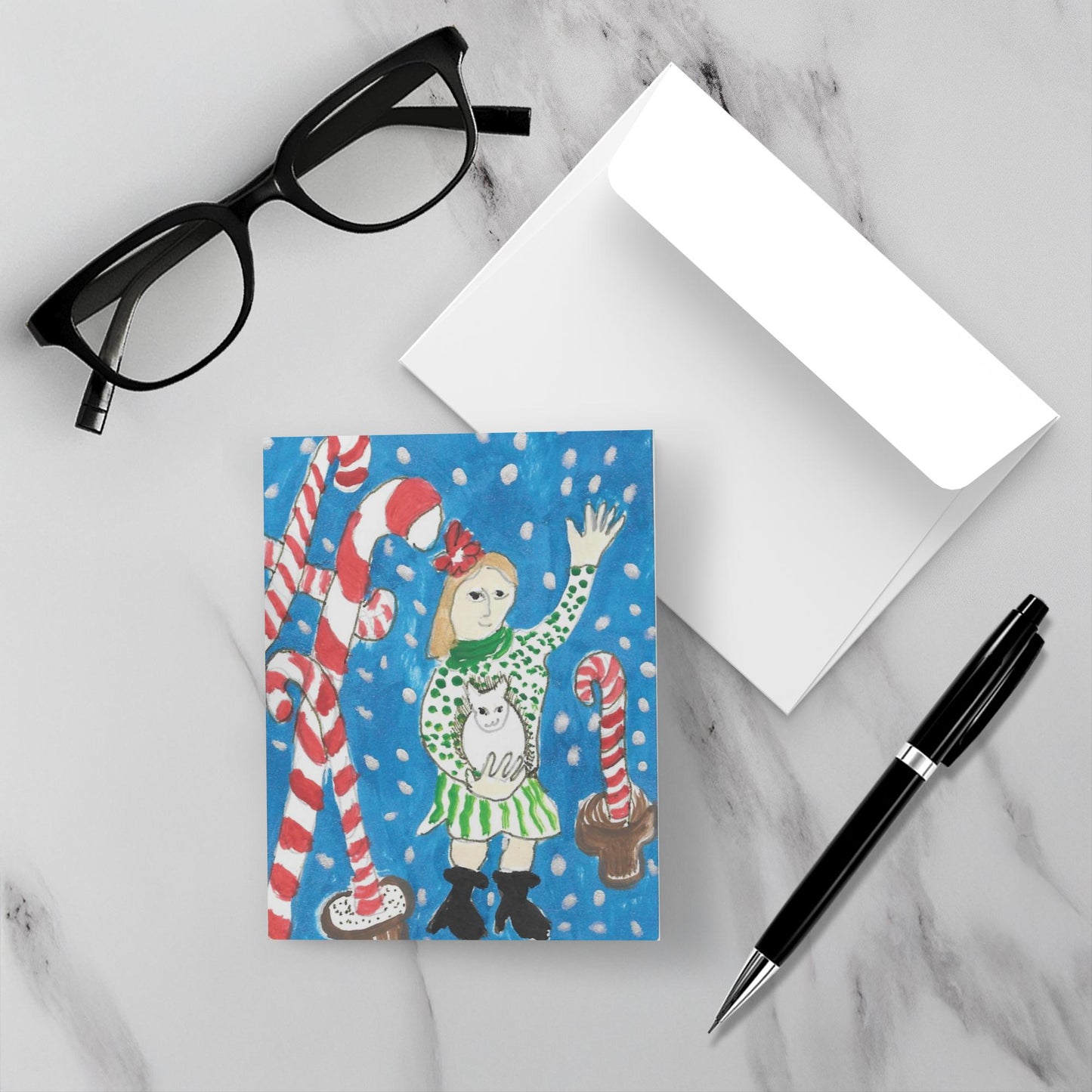 The front of the Holiday card with its envelope are on a marble surface.