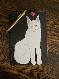 Mock up of the front of spiral notebook Love and Kisses Caspar by Janet Lee Chauncey. Printed by Chauncey Art Collective.
