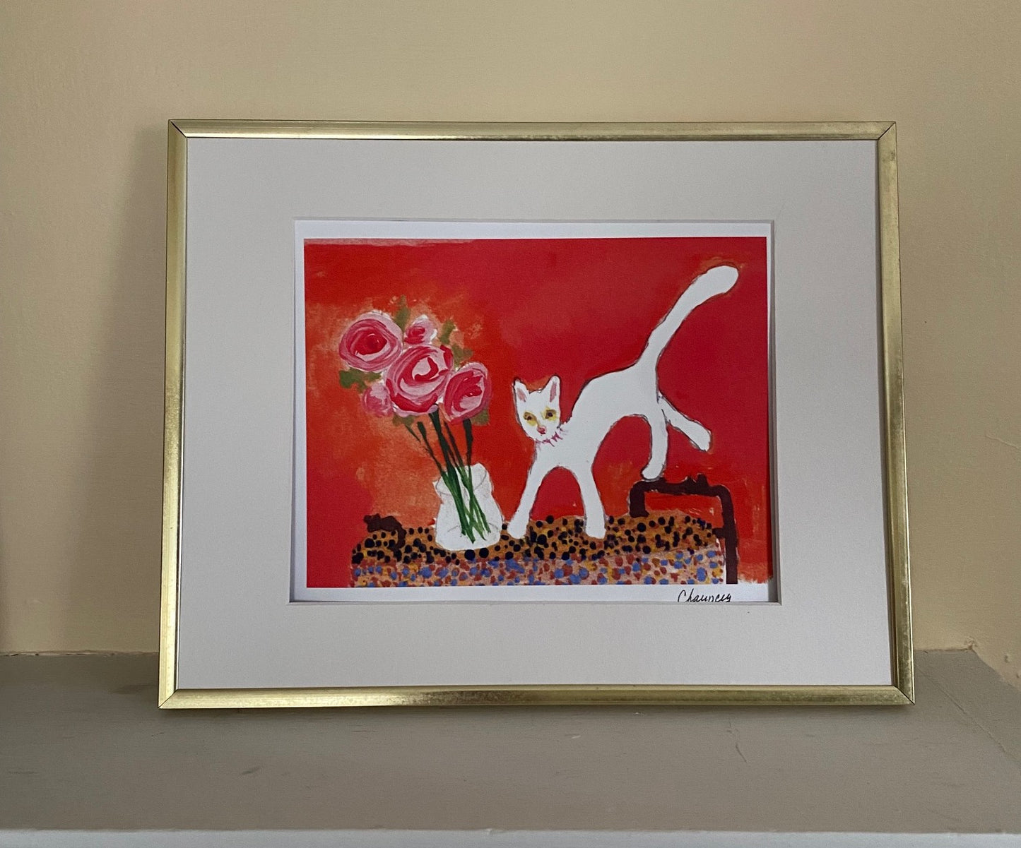 Placed in a gold frame with white matting Caspar With Roses colors really come alive. The orange background pops as does the white cat who has jumped on the table. The vase of pink roses is next to the cat.