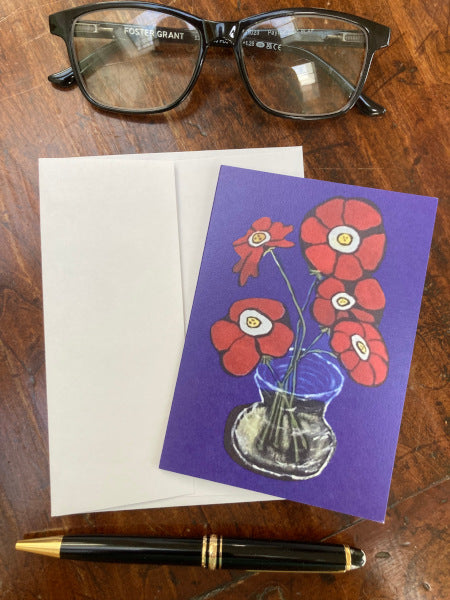 Mockup of notecard Flowers From The Garden with envelope on a wooden table with black reading glasses and a fountain pen.