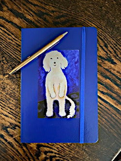 Mock up of the journal printed in blue with a gold pen across the top.