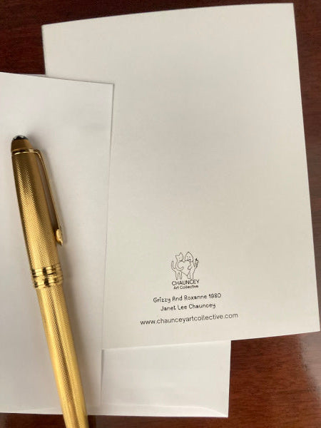 A mock of of the rear of the card showing the title and company logo accompanied by the envelope and a gold pen.