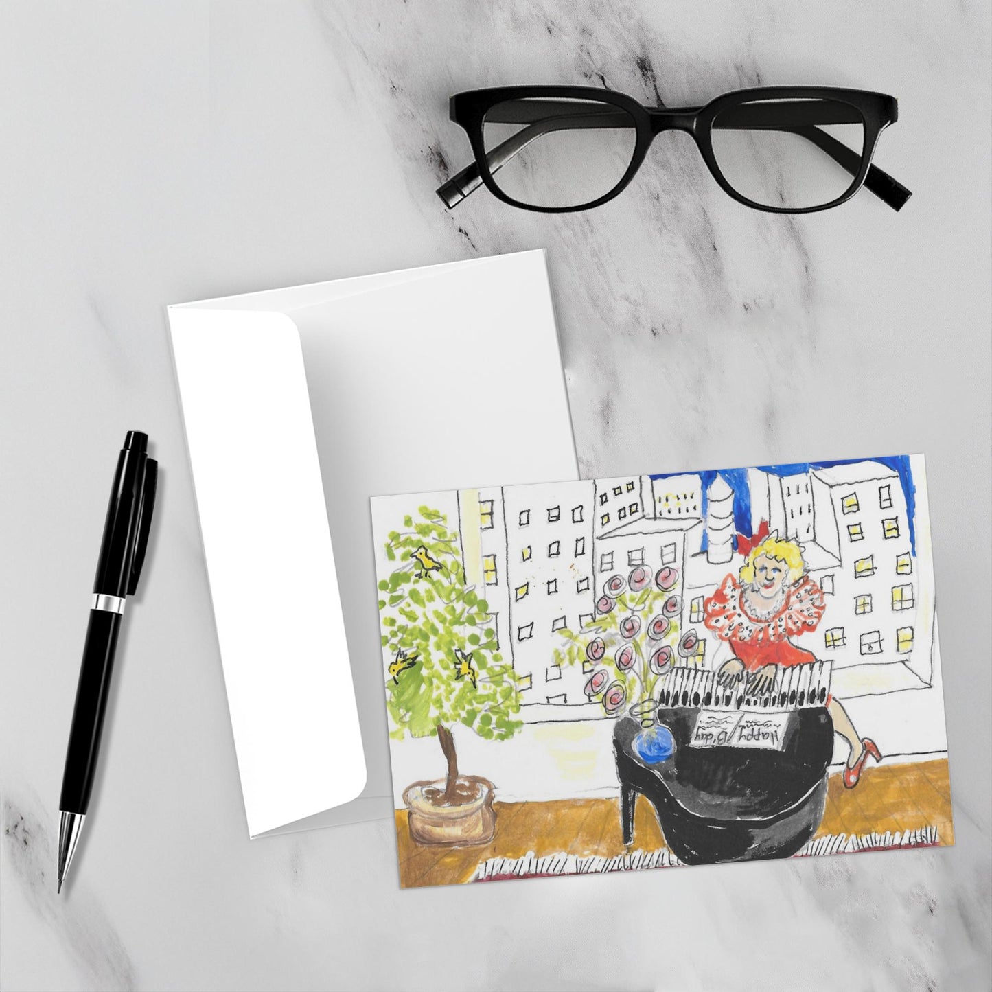 Mock up on a white marble backdrop of the front of the birthday card along with its envelope, a pen and reading glasses.