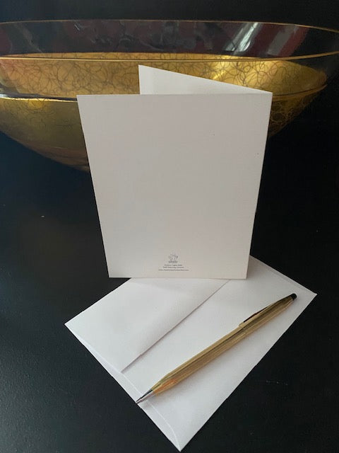 Mockup of the back of Outdoor Lights Christmas Card and envelope next to a golden bowl.