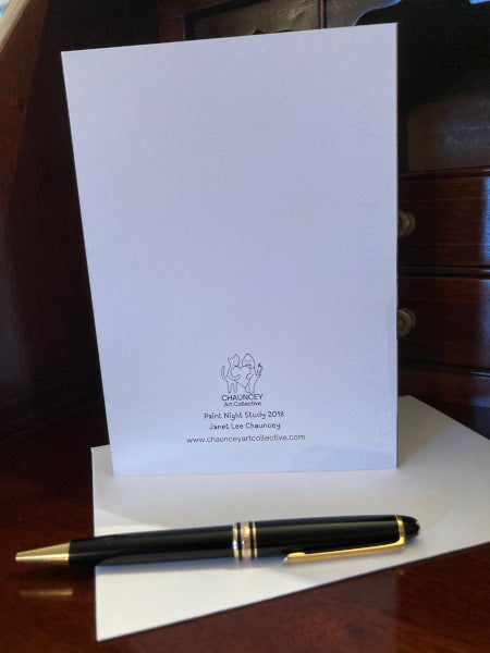 Mock up of the reverse side of the greeting card, placed on a wooden desk with its envelope and a pen.