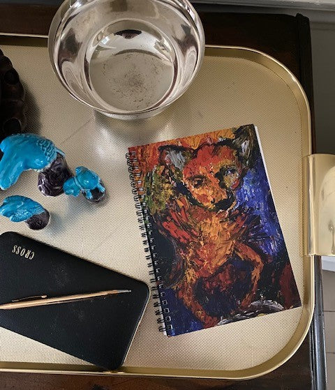 Mock up of Pepito spiral notebook on a gold tray near a silver bowl.