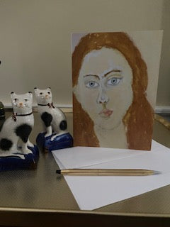 Mockup of Portrait Girl on a golden tray next to two Staffordshire cats and a gold pen.