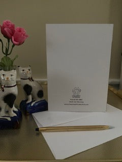 Mockup of the greeting car with two Staffordshire cats, miniature pink roses, the envelope and a gold pen