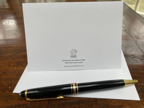 A mockup of the back of the card on its envelope accompanied by a black pen,