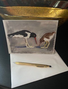 Mock up of Shore Birds with the front of the greeting card facing the camera showing the birds perfectly. They are on a black surface with a golden bowl behind them.