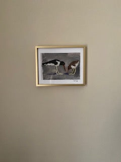 Mockup of an 8 x 10 print hanging in a gold frame on a beige wall.