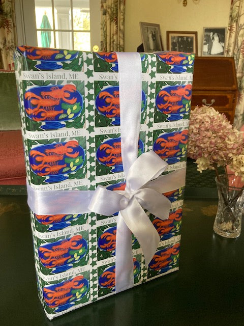 The vivid red, blue, green and white on the Swan's Island Wrapping Paper displays nicely in this mock up of a wrapped present with a white bow.