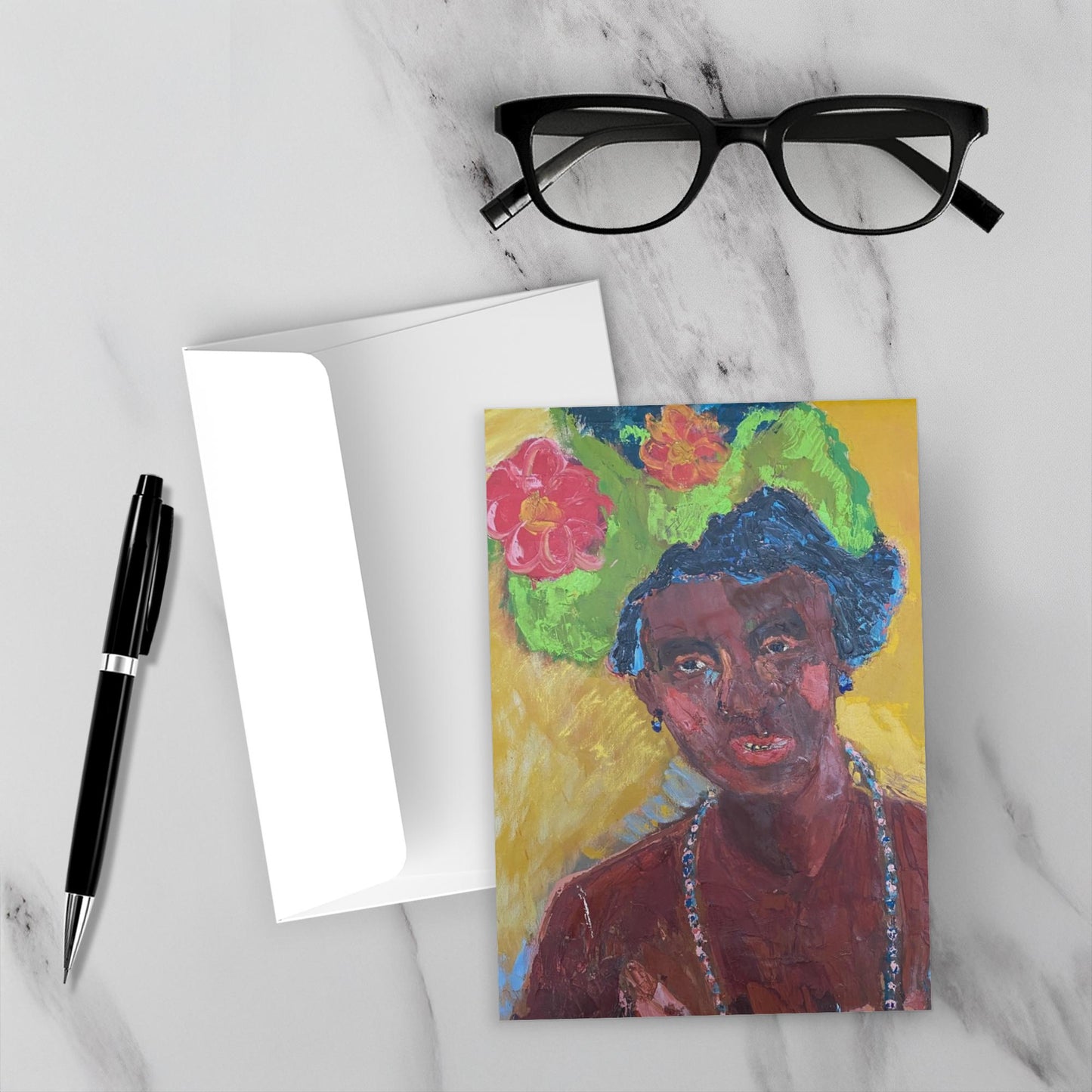 A mock up of the front of the all occasion greeting card Lady In Hat on a white marble background with black reading glasses and a black fountain pen