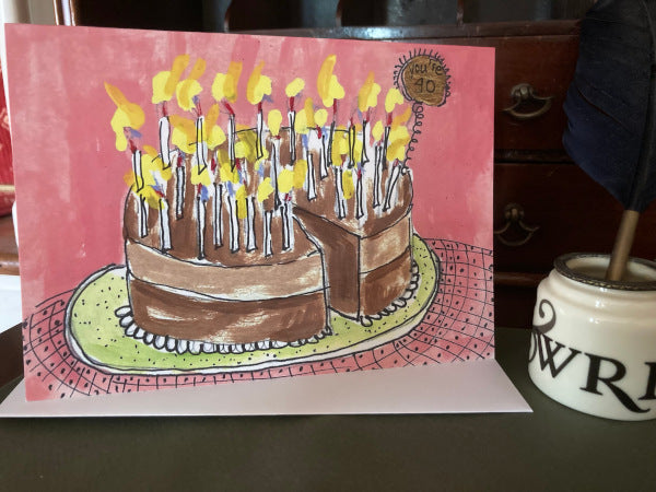 The front and the envelope of the birthday card You're 40! are sitting on a wooden table.