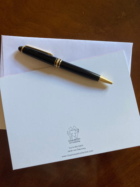 The back of the Card You're 60! displayed on a table top with a white envelope and black pen.