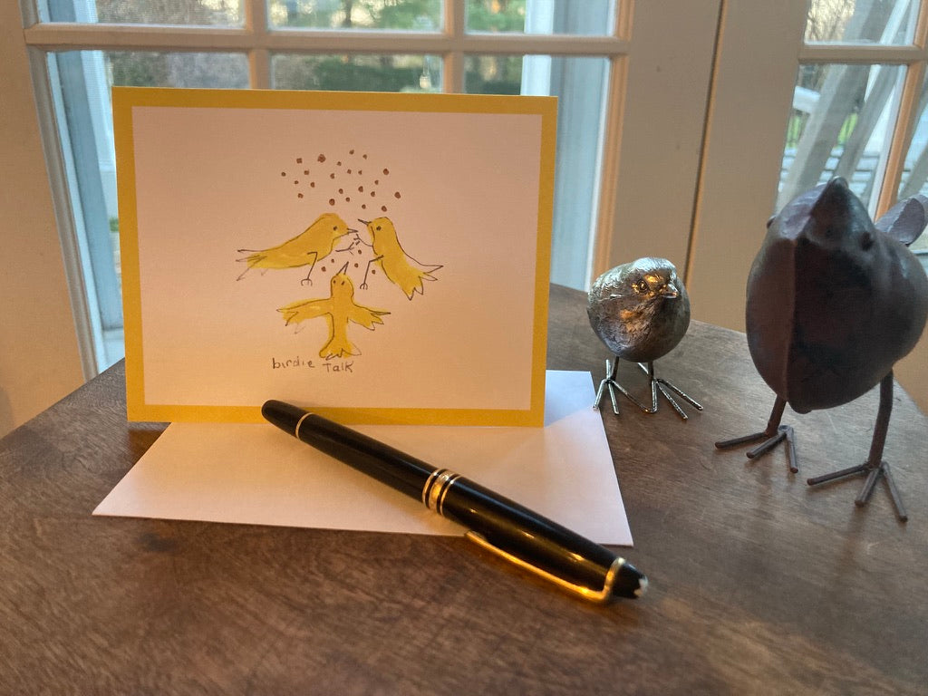 Greeting card by Janet Lee Chauncey with birds, pen, and decorative birds on a wooden surface.