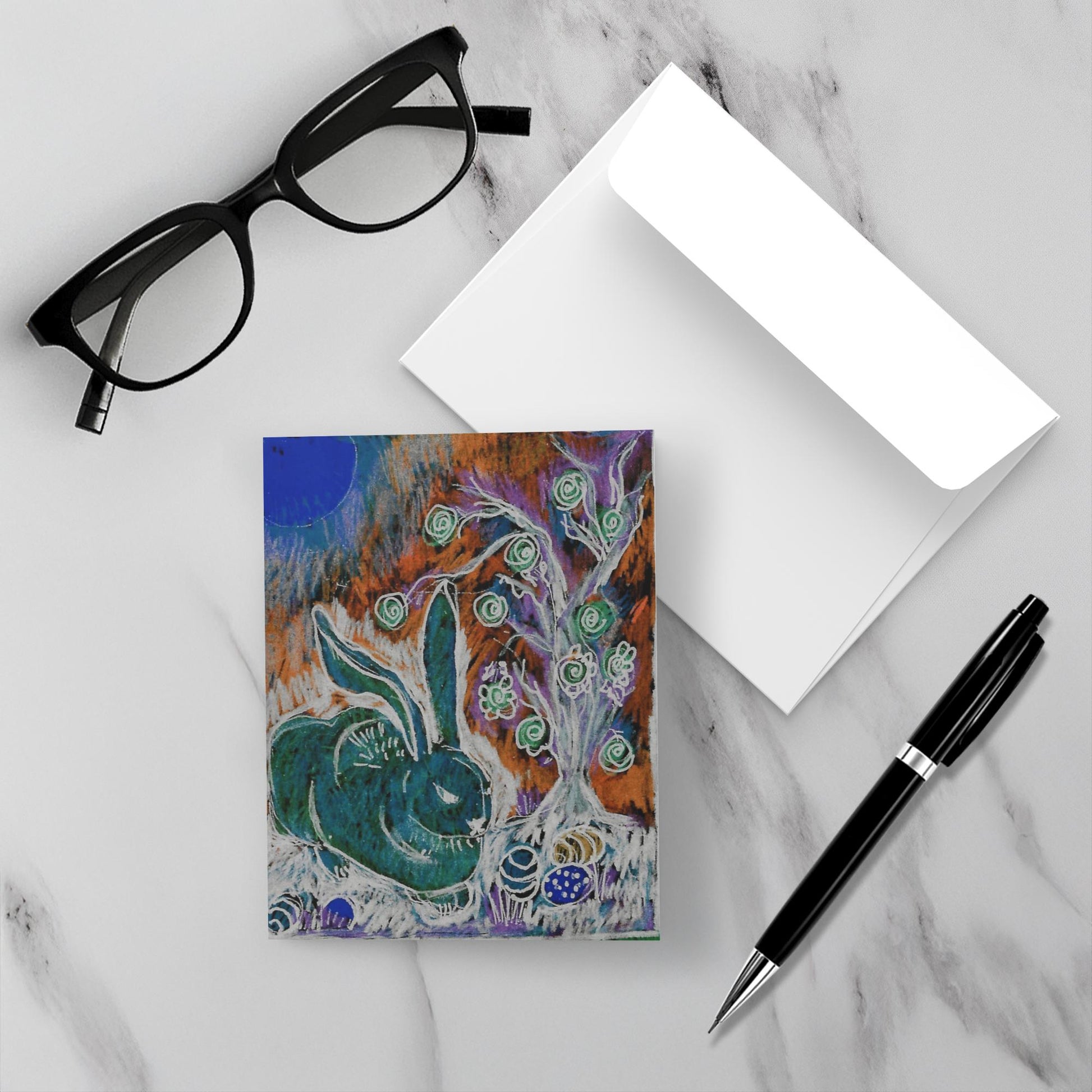 Bold Bunny notecard with its envelope a pen and eye glasses on a white marble surface.