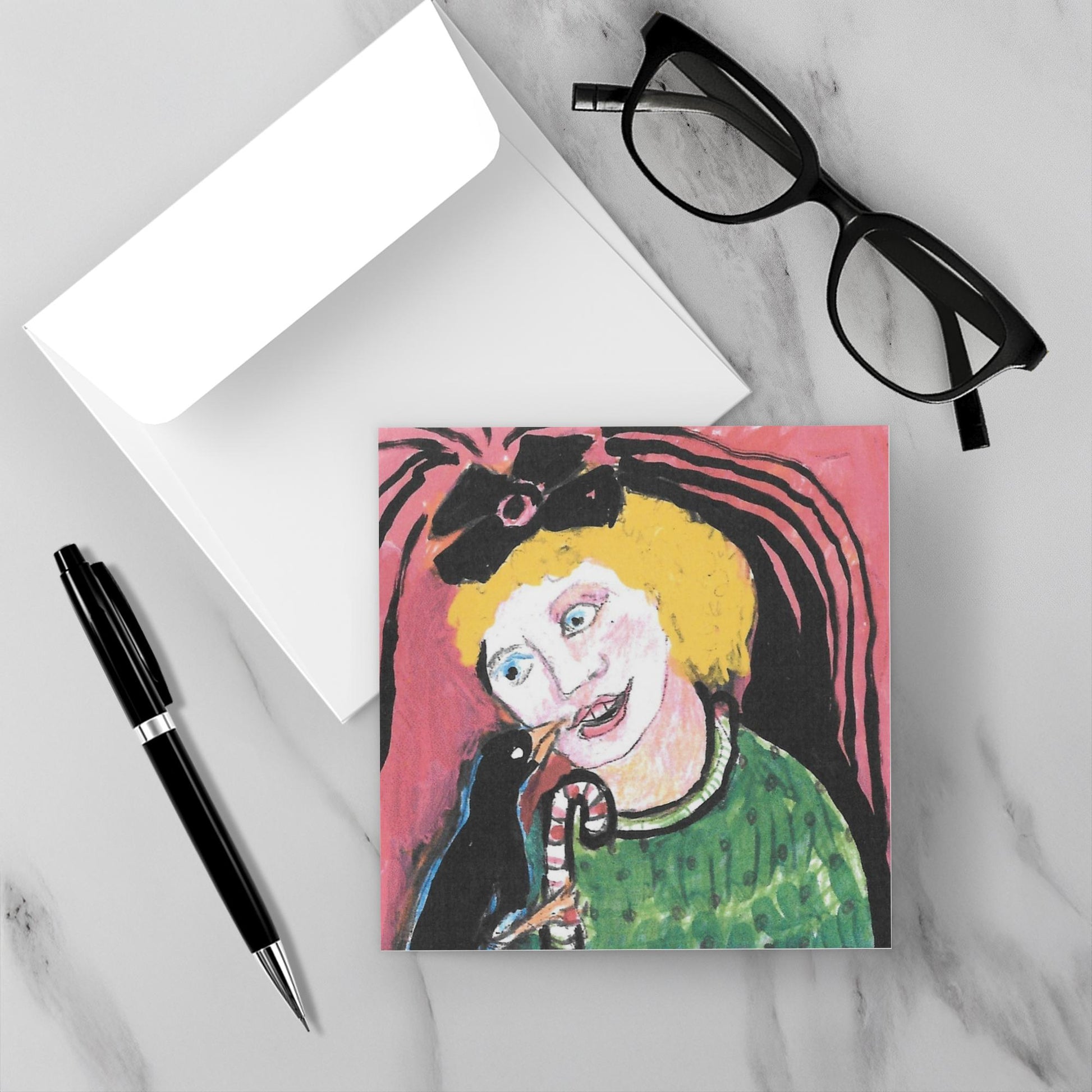 Small painting of a person with a black bird sharing a candy cane on a colorful background on a marble surface with glasses and a pen. Art by Janet Lee Chauncey.