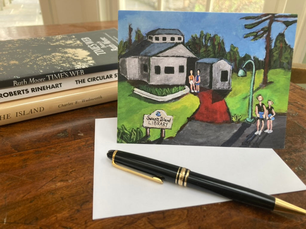 Island Chapters greeting card with a drawing of a library and people, placed on a surface with books and a pen.
