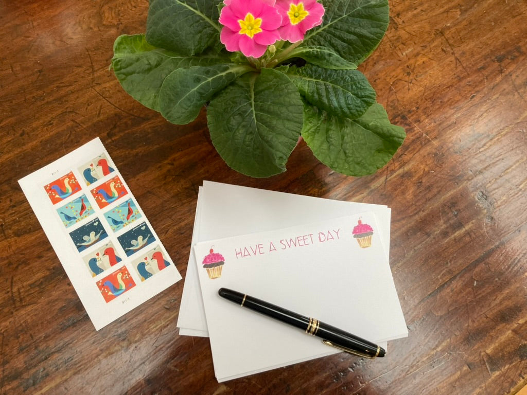 Notecard with stationery items on a wooden surface