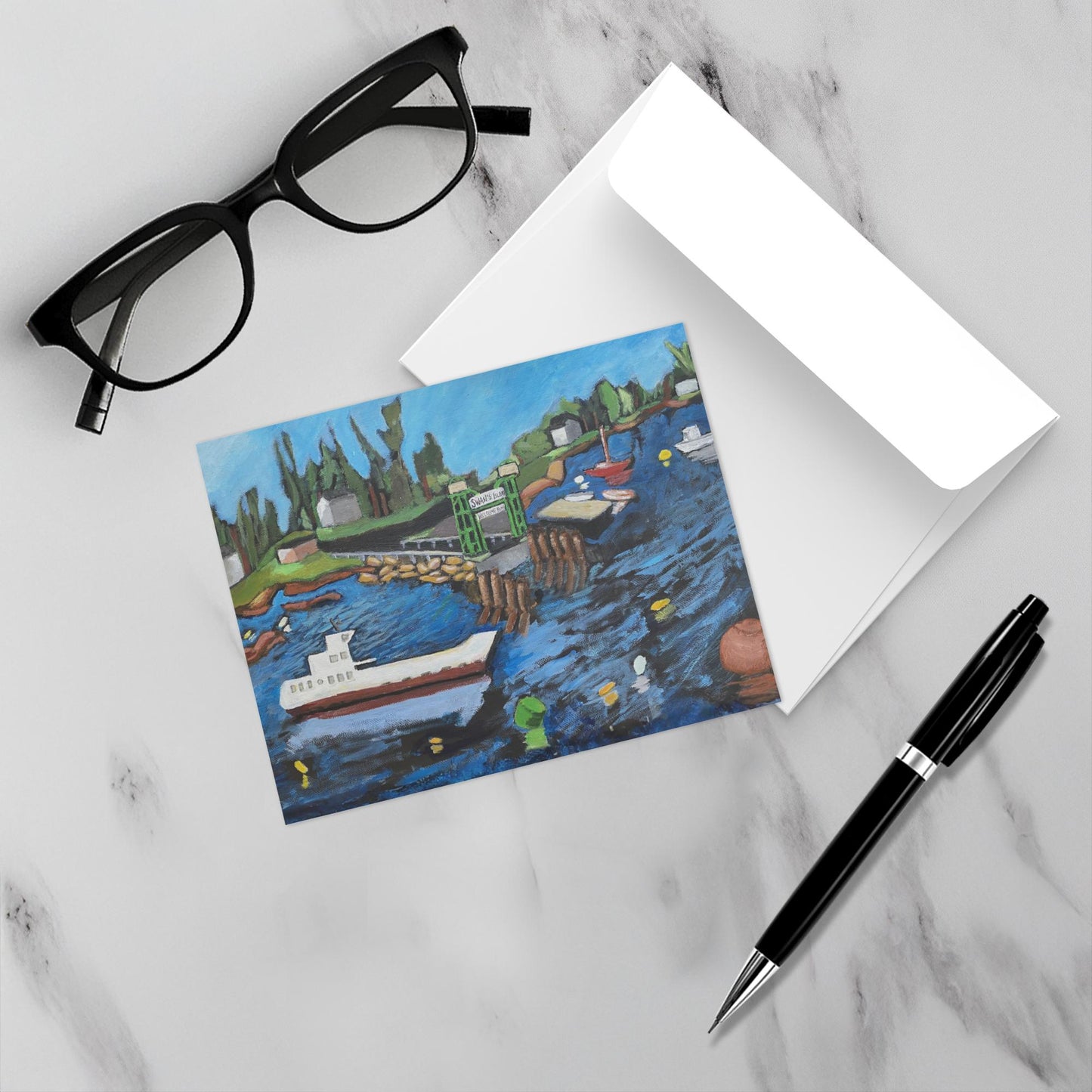 You have Arrived notecard on a marble surface with envelope, pen and eyeglasses. 