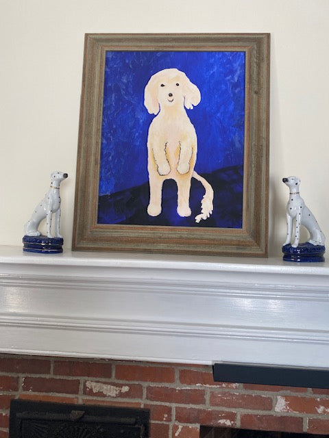 Framed artwork of a white dog on a blue background leaning against a wall.