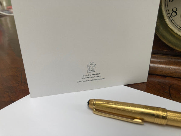 A golden pen and envelope complete the mockup of the back side of the greeting card Owl In Trees.