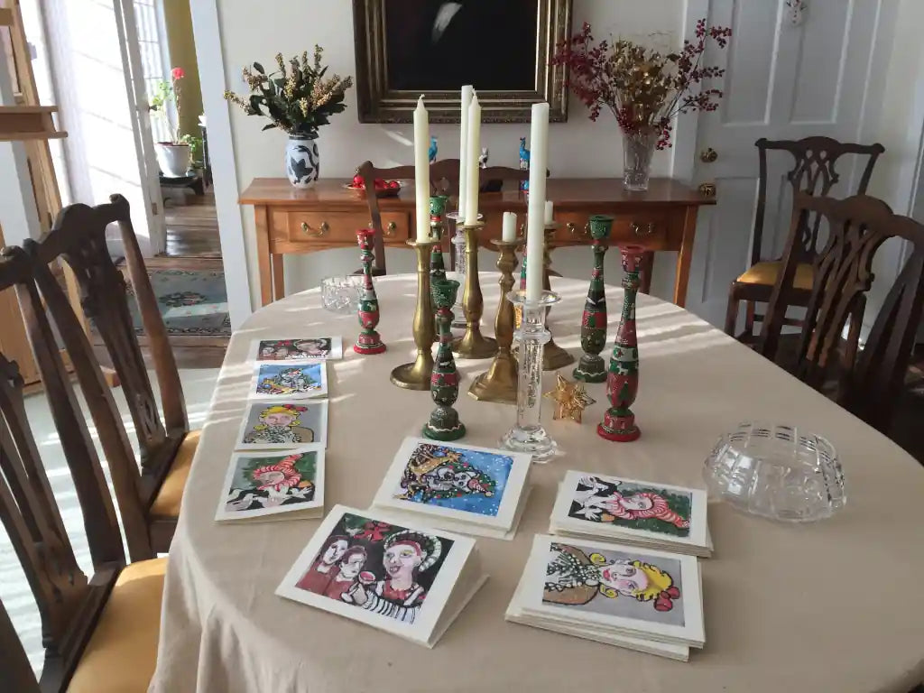 Dining room table with decorative cards, candles, and vases on a beige tablecloth.