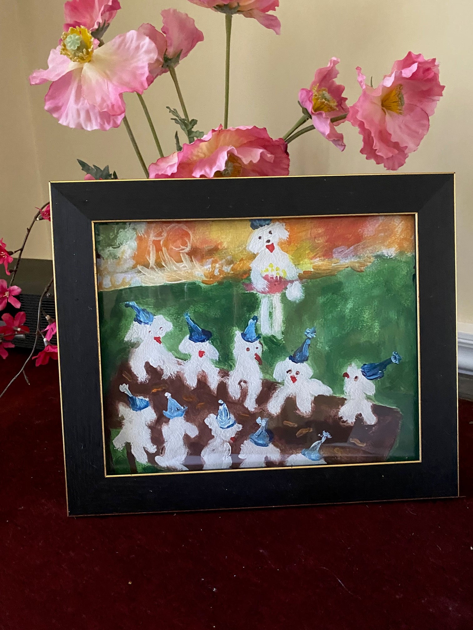 This framed mock up of art print Birthday Picnic showcases the vivid colors of the print. The whiteness of the Maltese dogs set against the green grass and orange sky make a striking image!