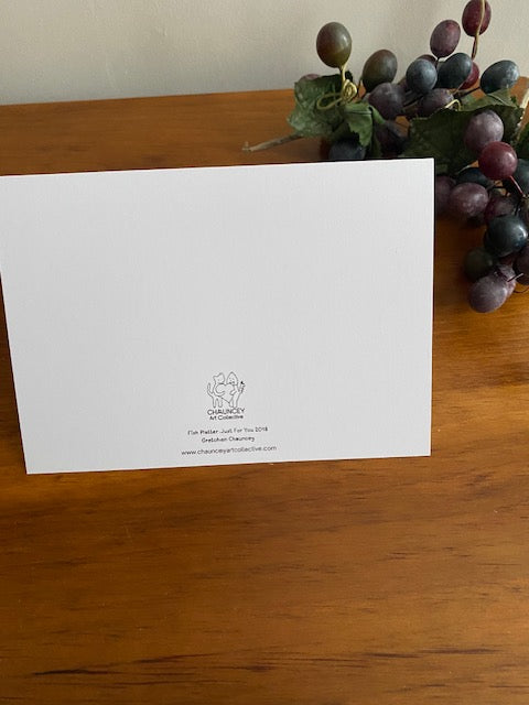 White card with a logo on a wooden surface next to grapes