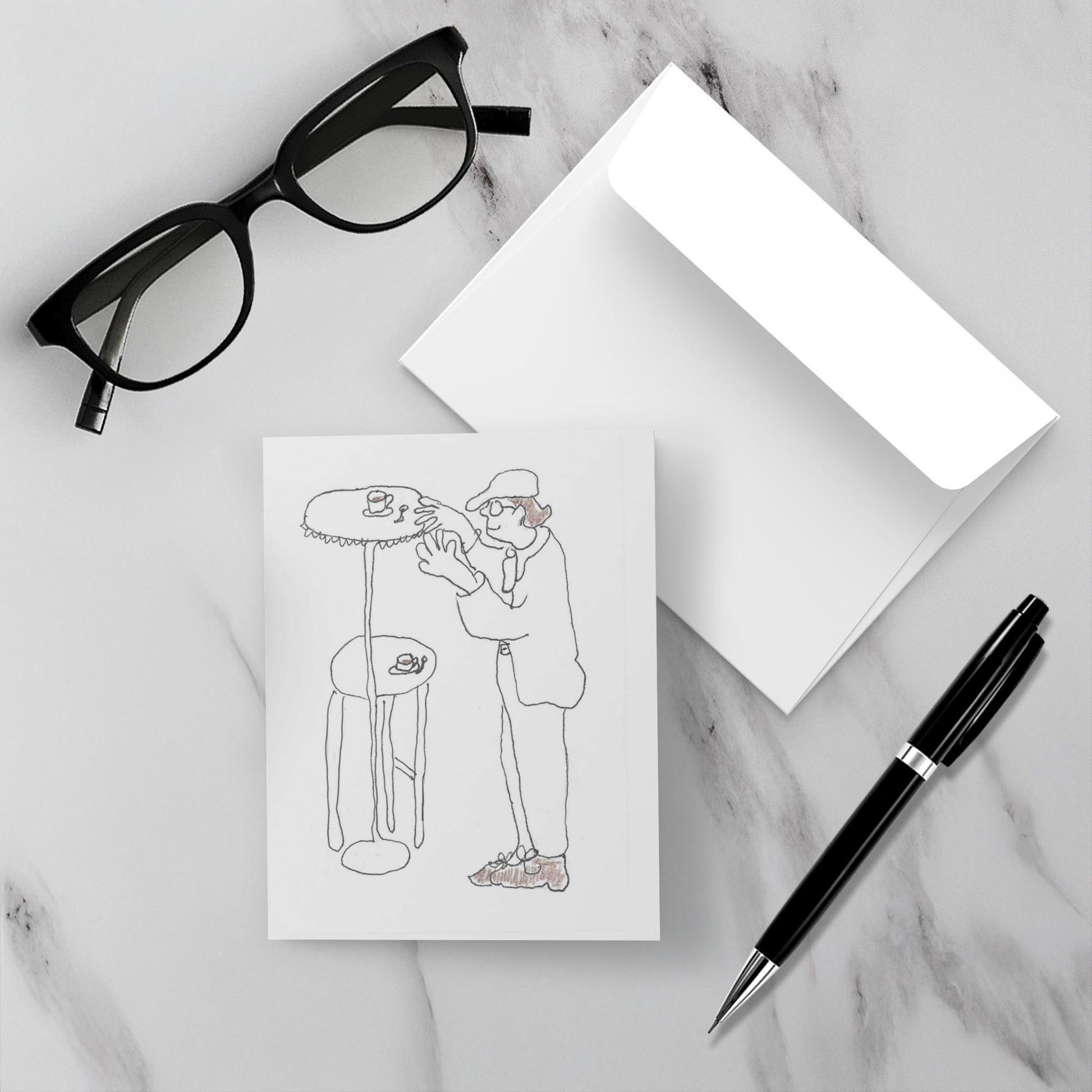 Mockup of the front and back of the greeting card titled High Top Table For Daddy lying on a grey marble surface with envelope and black pen and pair of black reading glasses