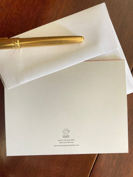 Photograph of the back of the card Jaunt In The Snow which shows the card flat atop its white envelope on a brown desk with a gold pen lying atop the envelope.