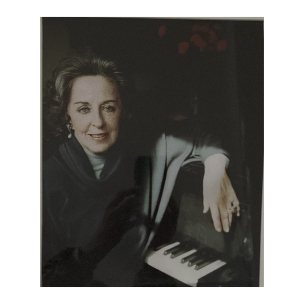 Jeanette At The Piano black and white photograph by Janet Lee Chauncey. A woman sits at her piano with sun illuminating her graceful hand. Chauncey Art Collective photo collection image for greeting card and hardcover journal.