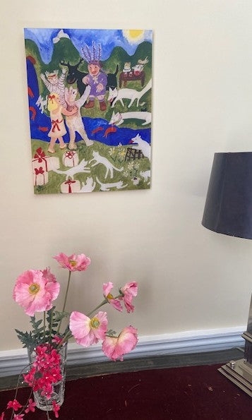 Chauncey Art Collective's Party Time acrylic art print hangs on the wall above a vase with pink flowers and a lamp with a black shade.