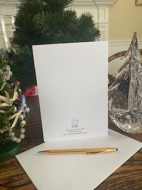 White card with text on a wooden surface next to a decorative wreath and pen