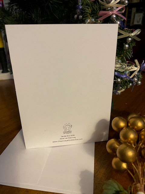 White card with a title Candle Glow and Chauncey Art Collective's logo on a wooden surface with decorative items in the background